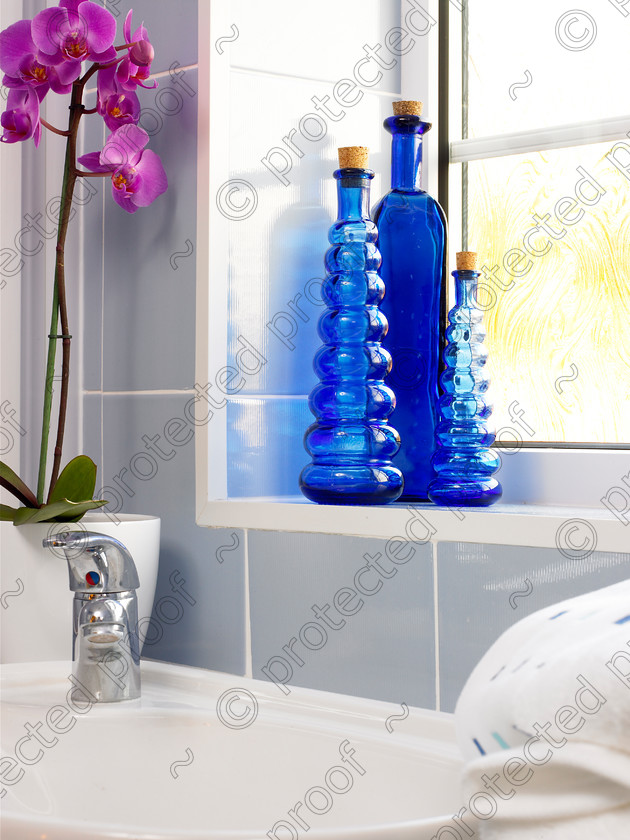 Bathroom-6 
 Orchid by bathroom sink. 
 Keywords: bathroom, sink, taps, orchid, blue, bottles, tiles, window, ledge, towel